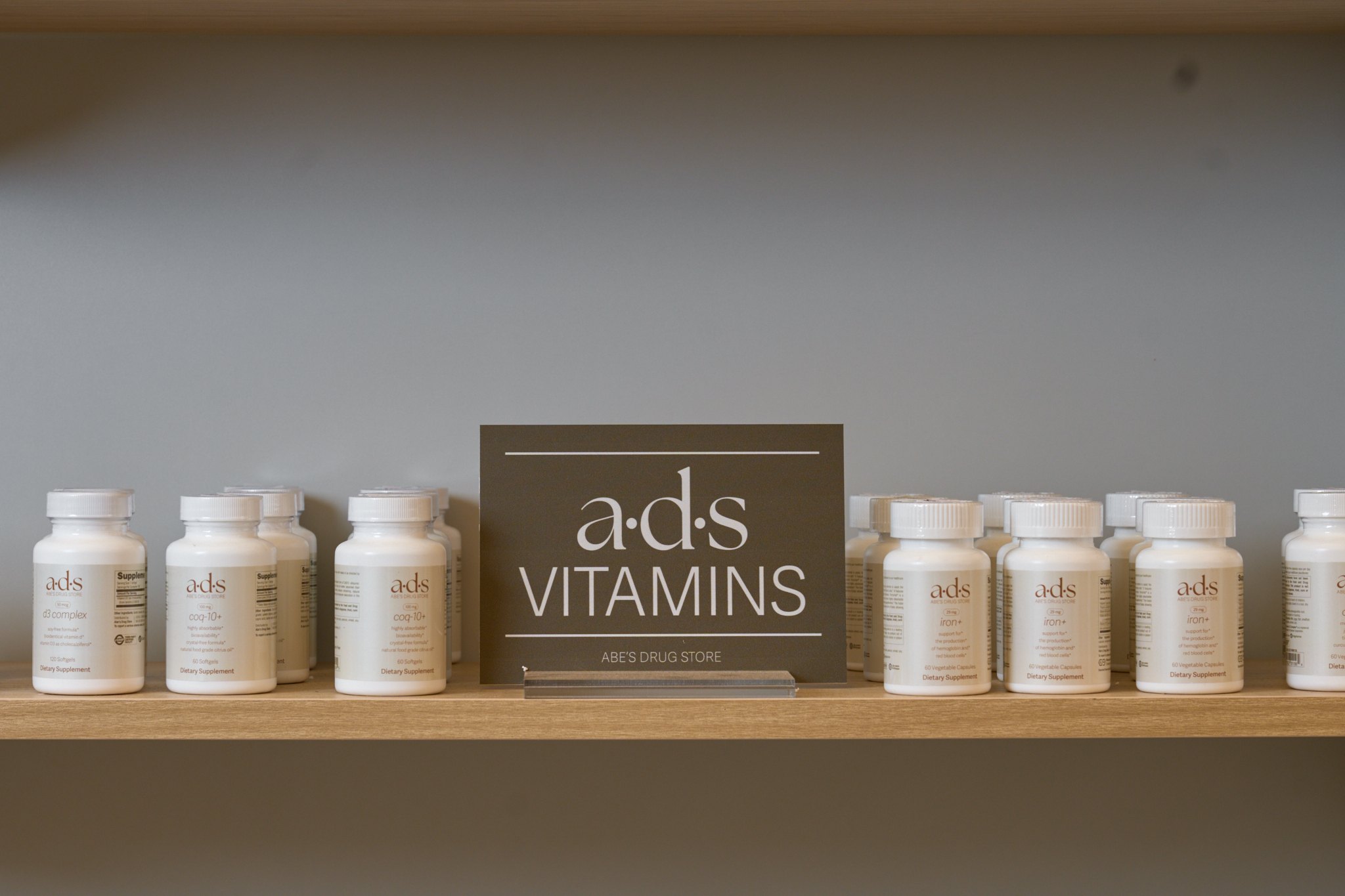 a·d·s vitamins on a wood shelf with an a·d·s Vitamins card