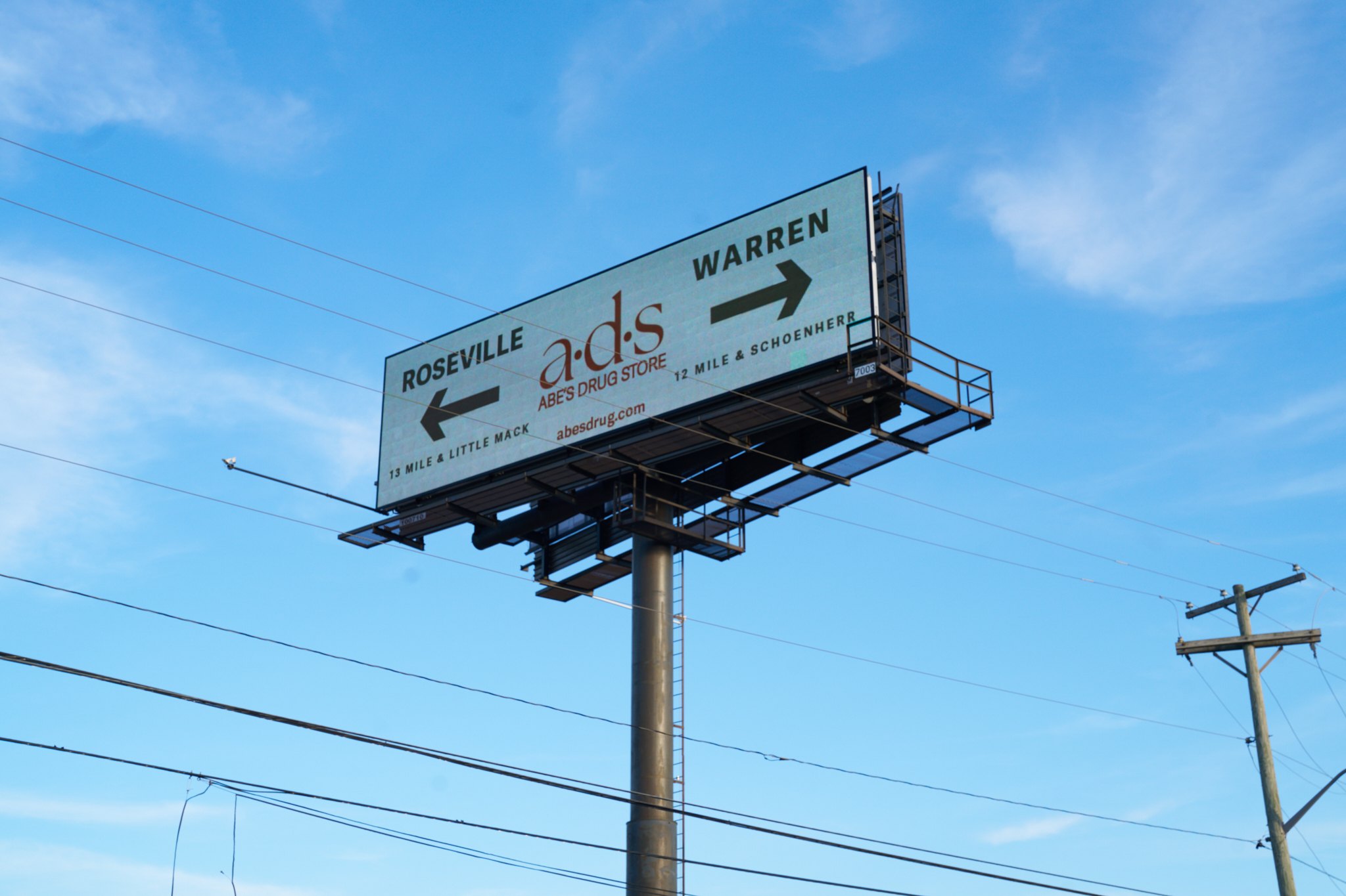 a·d·s billboard pointing to Roseville and Warren